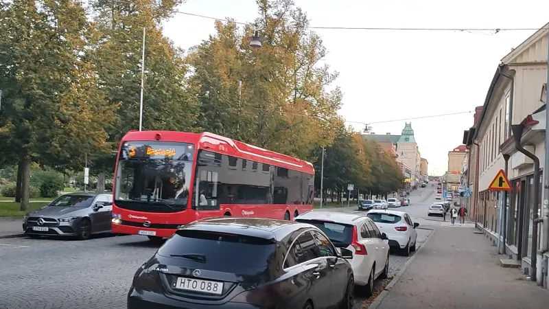 Вулиця у Карлскруні з червоним автобусом і припаркованими автомобілями